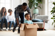 Happy black family play with kids moving to new home