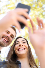 Wall Mural - Happy couple using smart phone together in a park