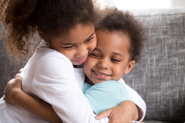 Wall Mural - Cute mixed race kids hug making peace at home