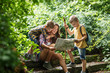 © BalanceFormCreative - Mother and her little sons hiking .They taking a break and sitting on the old stairs.Examining map.
