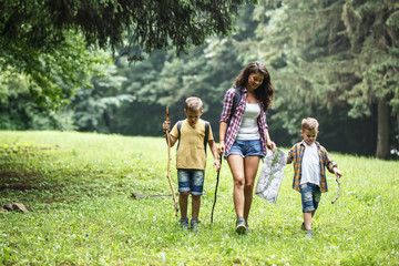 Wall Mural - mother and her little sons hiking trough forest .