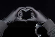 Mens Hands Shaping The Handcuffs Like A Heart On Black