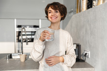 Smiling Young Woman Holding Glass Of Water