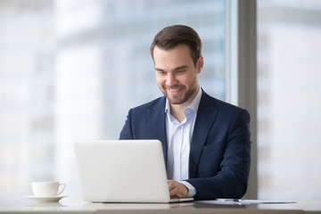 Poster - Happy businessman in suit using laptop software at workplace