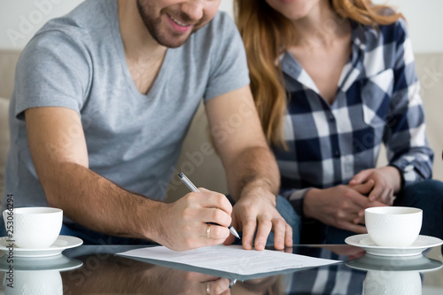 Fotografía Tenants write signature on rental sale agreement, close up view