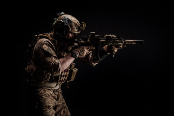 Wall Mural - Special forces United States soldier or private military contractor holding rifle. Image on a black background. war, army and people concept