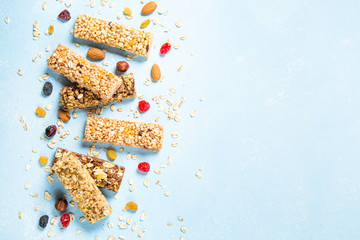 Granola bar with nuts, fruits and berries on blue.