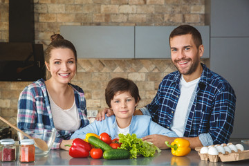 Wall Mural - Family at home standing in kitchen together looking camera happy excited