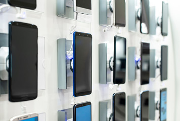 Smartphones on shelf in the store. Concept for communications and technology.