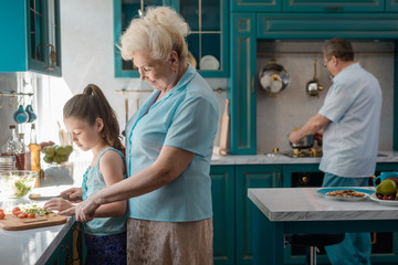 Wall Mural - Grandparents and child cooking meal