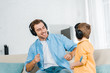 © LIGHTFIELD STUDIOS - happy father with preschooler son in headphones listening music at home