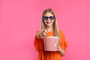 Canvas Print - Teenage girl with 3D glasses and popcorn during cinema show on color background