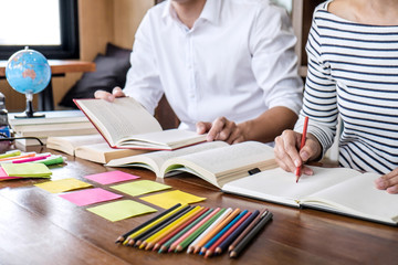 Wall Mural - high school or college student group sitting at desk in library studying and reading, doing homework