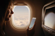 © minastefanovic - Woman in airplane using mobile phone