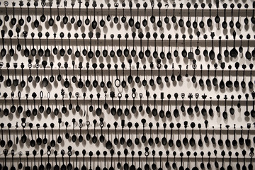 Wall Mural - Art installation of 2000 black souvenir spoons on a white wall by Chantal Gibson at the Toronto Royal Ontario Museum