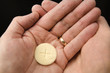 Cupped hands of a man holding a wafer of bread The Body of Christ when receiving communion at a Roman Catholic Mass