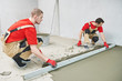 © Kadmy - Floor cement work. Plasterer smoothing floor surface with screeder