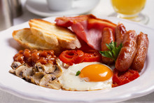 Full English Or Irish Breakfast With Sausages, Bacon, Eggs, Tomatoes, Mushrooms And Beans. Nutritious And Healthy Morning Meal.