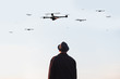man looking at the sky full of drones
