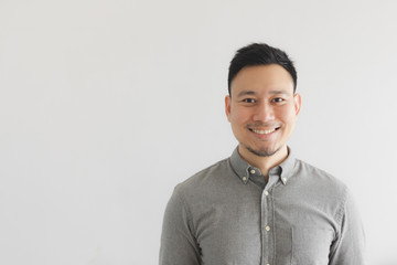 Smile happy face of ordinary man in grey shirt. Concept of charming and positive thinking.