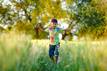 Indian child playing with the color in holi festival