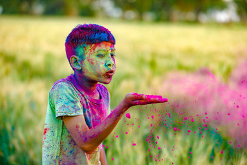 Indian child playing with the color in holi festival