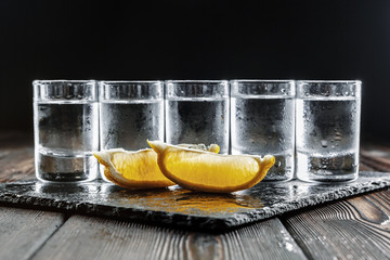 Vodka in shot glasses on rustic wood background