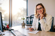 © Jacob Lund - Smiling female doctor sitting her office desk