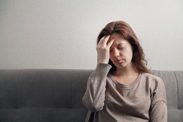 Young attractive woman in depression with a headache.