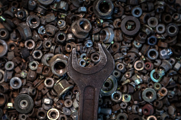 Flat Lay metal wrenches on the background of various metal cogs, screws and nails, top view. Close-up Carpenter's Tool Kit