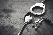 Drug Syringe And Cooked Heroin On Spoon And Handcuffs . Concept - Punishment For Possession Of Narcotic Drugs.