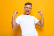 © Drobot Dean - Happy excited man posing isolated over yellow wall background make winner gesture.