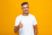 Handsome Emotional Man Posing Isolated Over Yellow Wall Background Showing Thumbs Up Gesture.