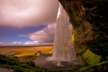 View Of A Waterfall In Iceland. Water Flows From Top To Bottom.
