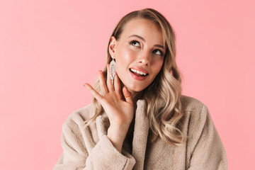 Pretty woman posing isolated over pink wall background wearing accessories and jewelry.