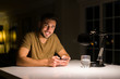 © Krakenimages.com - Young handsome man studying at home , using smartphone, smiling at the camera