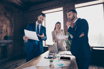 Close up photo three one team career partners she her business lady he him his guys wrong data numbers charts check income thoughtful busy ponder pensive stand office table wearing formal wear suit