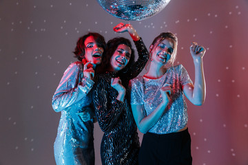 Wall Mural - Three cheerful beautiful women wearing bright clothes