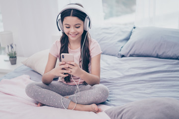 Poster - Close up photo cute beautiful she her little girl smart phone hands earflaps turn on favorite modern song curly wavy wear home t-shirt pants comfortable apartments flat bright light colored room