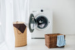 opened washer and brown baskets in laundry room