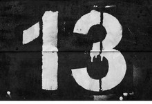 Number 13 In Stencil On Metal Wall In Black And White.