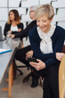 © contrastwerkstatt - Businesswoman checking her mobile during meeting