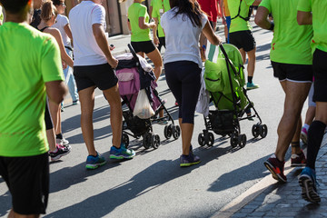 Wall Mural - Parents with Pushchairs for Children in a City Marathon Race Event