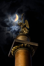 Angel On Alexander Column On Palace Square On The Background Of The Moon In St. Petersburg.