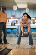 © Erickson Stock - Smiling mid adult woman throwing a bowling ball.