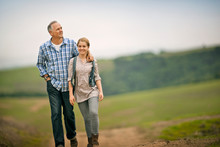 Smiling Middle Aged Man Walking With His Teenage Daughter.