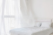 Abstract white bedroom interior. Total white bedroom with window with flying curtains. Morning breeze concept