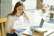 © Vasiliy - beautiful girl businesswoman in a cafe writing in a notebook talking on the phone