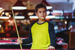 © Natali - Cute boy in yellow t shirt plays billiard or pool in club. Young Kid learns to play snooker. Boy with billiard cue strikes the ball on table. Active Leisure, sport, hobby concept