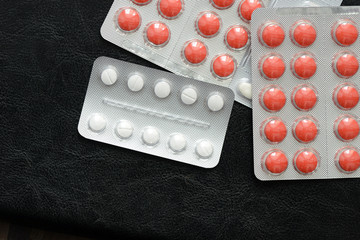 Pills and tablets packages  on a dark background close up